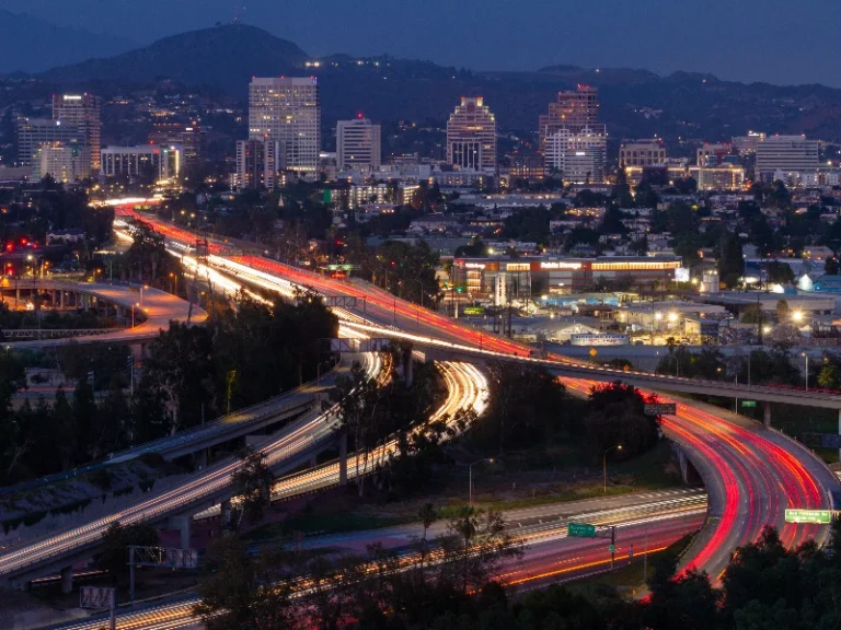 City skyline at night with highways showing light trails from moving vehicles. Shows that the company does emergency flood cleanup in Glendale CA.