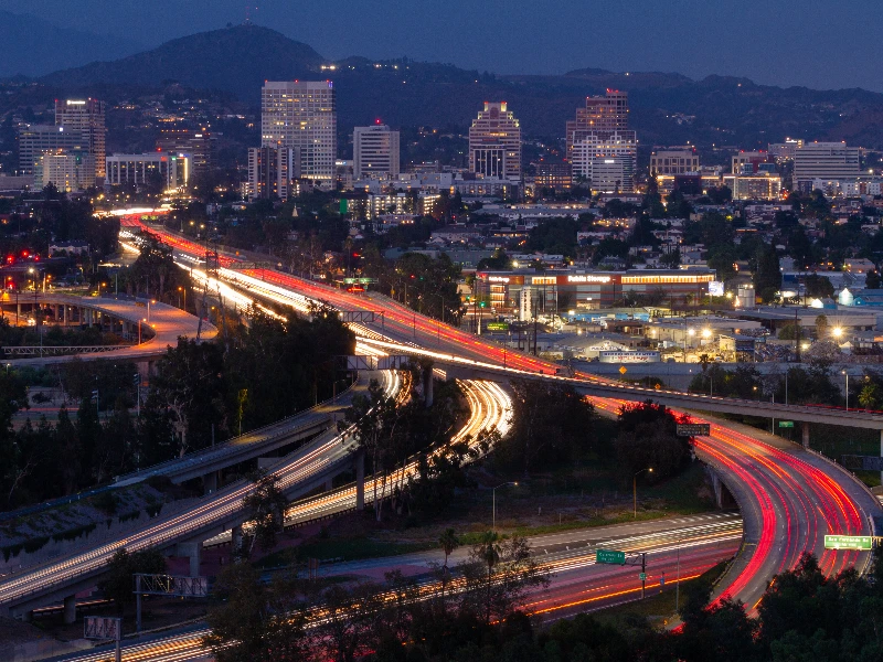 City skyline at night with highways showing light trails from moving vehicles. Shows that the company does emergency flood cleanup in Glendale CA.