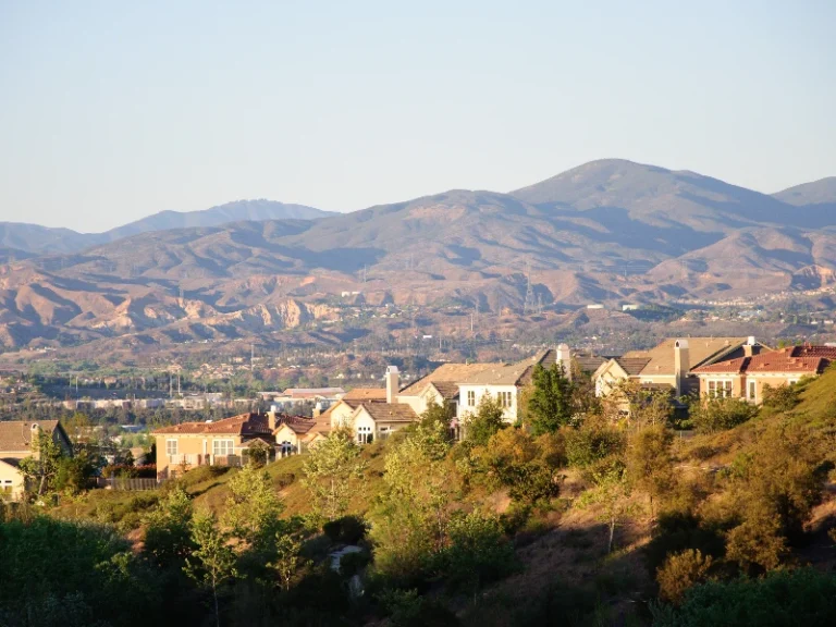 Suburban houses on a hillside with mountains in the background under a clear sky. Showcases that the company does emergency water damage cleanup in Santa Clarita CA.